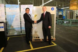 Jiro Tomita, director and senior executive officer of Daikin Industries LTD, congratulates Sam Bickman, senior vice president operations and logistics Daikin North American LLC, on the delivery of the first VRV heat pump assembled in North America.